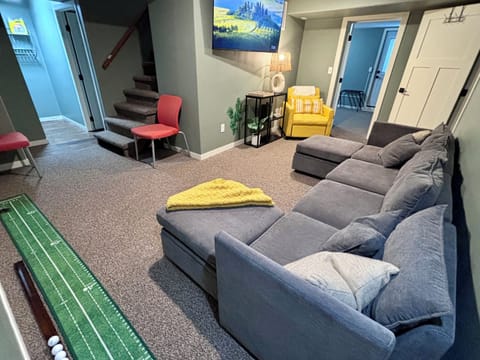 Living room featuring 55” big screen TV, indoor golf, pull out couch & sofa bed