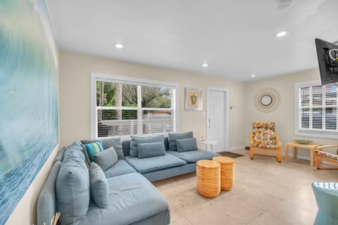 Unwind in a charming and laid-back living space, complete with a comfortable sofa and a spacious TV for your enjoyment.