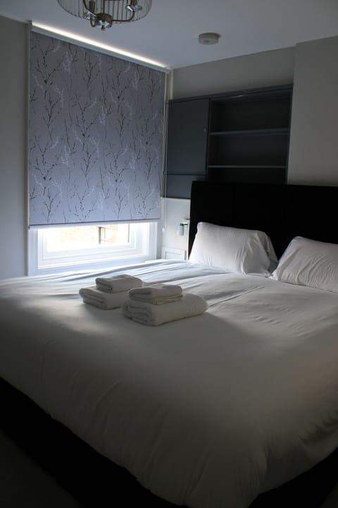 King Suite Bedroom with Super king bed, flat screen television and clothes hanging racks