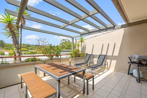 Enjoy the outdoor balcony flowing seamlessly from the living area that is complete with a barbeque, table, and chairs to dine and relax.