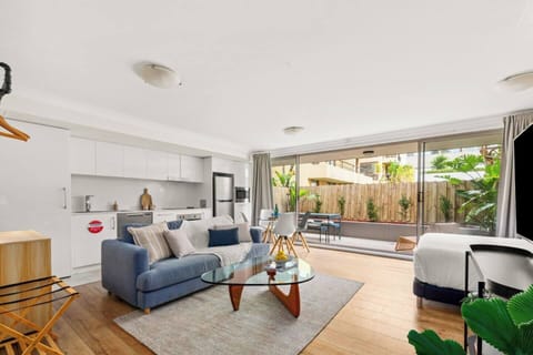 The living area offers garden views from the balcony. Floor-to-ceiling windows invite fresh air and breezy ambiance.