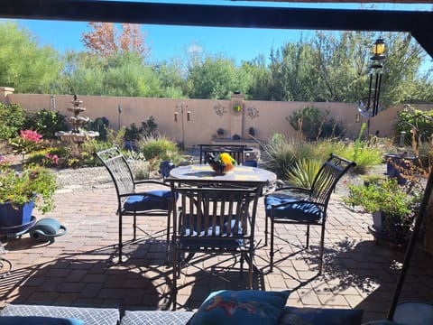 View from living room into backyard garden with water fountain.