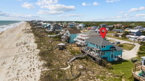 Beachfront vacation rental community with direct beach access and elevated boardwalk paths to sandy shores.