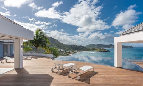 Heated pool shaped like a nautilus shell, deck chairs, sun beds. 