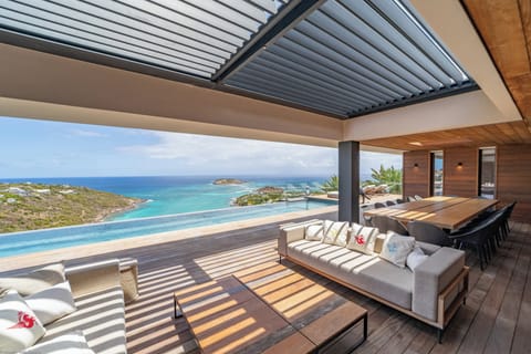 Expansive lounge area on the covered terrace, facing the panoramic view. 
