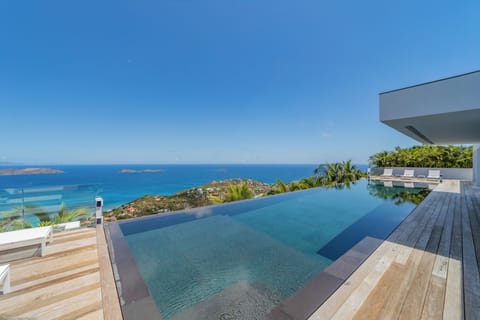 Expansive terrace with deck loungers, long heated pool facing the panoramic views. Outdoor lounge area under the gazebo. 