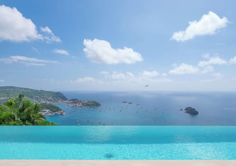 Magnificent heated pool facing the view, expansive terrace with loungers and deck chairs. Lounge area on the covered terrace. 