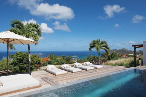 Large infinity pool (8m x 3,5m) with wading area and stairs, surrounded by a spacious wood deck with 6 lounge chairs. Ocean & sunset view.