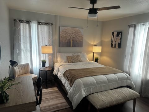 first bedroom with queen bed extra pillows and blanket