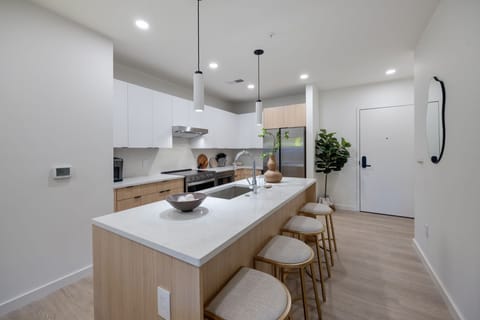 Fully equipped kitchen boasting brand-new stainless-steel appliances and a large island with bar seating stocked with all culinary essentials for ease and convenience during your stay.