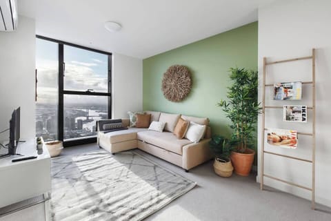 Embrace the serene charm of this sunlit living room, featuring a fold-out sofa bed and sweeping city views.