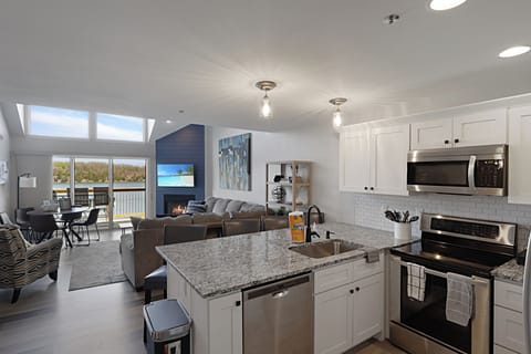 Your spacious open-concept haven features a gourmet kitchen with granite counters, cozy living area with fireplace, and stunning lake views.