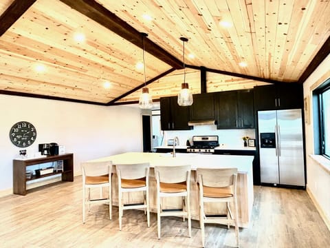 The open kitchen features vaulted ceilings, stainless steel appliances and more.