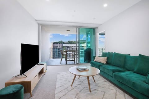The light-filled living area includes a large sofa and TV, with split system air-conditioning ensuring year-round comfort.
