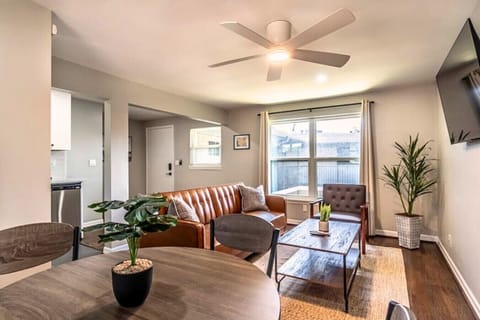 Bright, stylish living space with a modern leather sofa, smart TV, and cozy decor for relaxing.