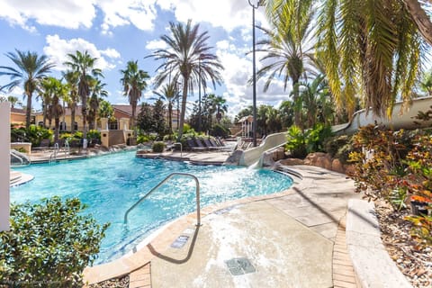 A sparkling resort pool surrounded by tall palms and lush greenery, offering a tropical oasis for sun-filled days.