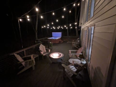 Large deck with salt water hot tub, firepit, dining area, and Weber gas grill.