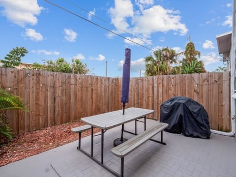 Patio with sun loungers, dining table and grill. 