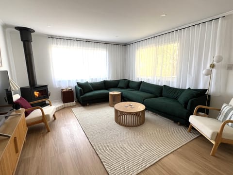 Lounge room with large six-seater couch and fireplace