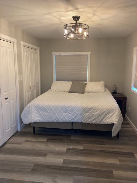 Master bedroom with king size bed, smart tv, double closet, and ceiling fan.