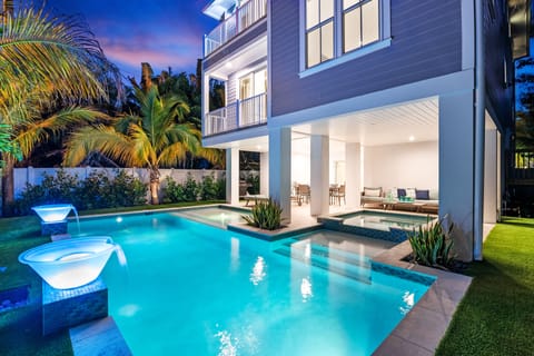 As the sky glows, relax in the lanai's cushioned lounge while twin glass bowls cascade water gently into the pool.