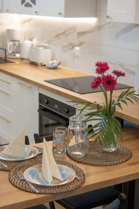 A decorative tray with flowers and glasses on the dining table.