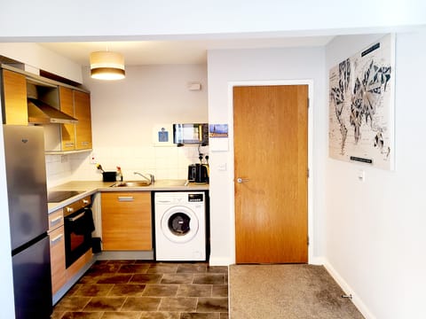 Kitchen, with microwave, kettle, toaster, washing machine, coffee and tea.