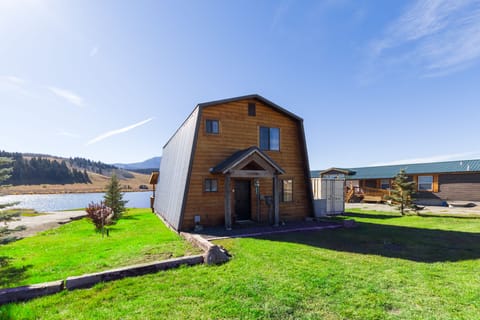 The front of the cabin presents a picturesque view, leading seamlessly to the tranquil lakeshore, offering a serene welcome to guests.
