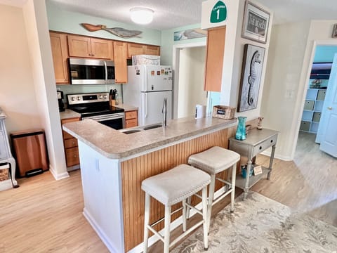 Kitchen - Well-appointed kitchen featuring lots of counter space, upgraded appliances, and a breakfast bar, ideal for preparing home-cooked meals.