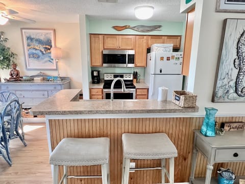Kitchen - Well-appointed kitchen featuring lots of counter space, upgraded appliances, and a breakfast bar, ideal for preparing home-cooked meals.