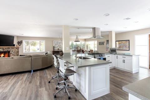 Open seating bar around the kitchen area with views of the pool and backyard.
