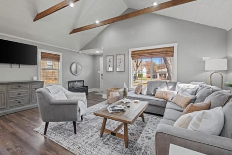 Bright and spacious living room with vaulted ceilings, exposed beams, and comfortable seating—perfect for relaxing after exploring Kansas City.