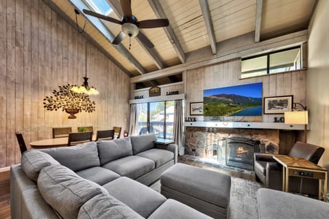 Relax in your spacious living room featuring exposed beams, fireplace, and plush sectional seating perfect for cozy evenings together.