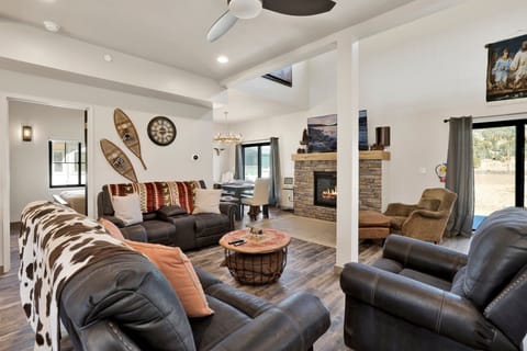 Cozy mountain living room with a stone fireplace, comfy seating, and smart TV perfect for relaxing evenings, movie nights, and warm cabin vibes after outdoor adventures.
