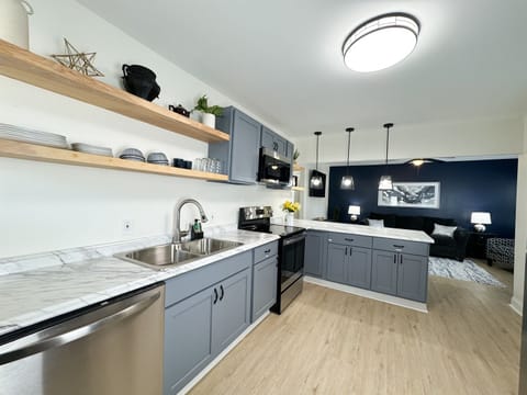The full size kitchen features a dishwasher, stove, microwave, refrigerator, and coffee bar