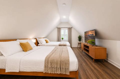 Bedroom 3: Spacious bedroom featuring two comfortable queen beds with soft linens and a relaxing ambiance. Perfect for families or groups, offering plenty of room to rest and unwind in comfort.