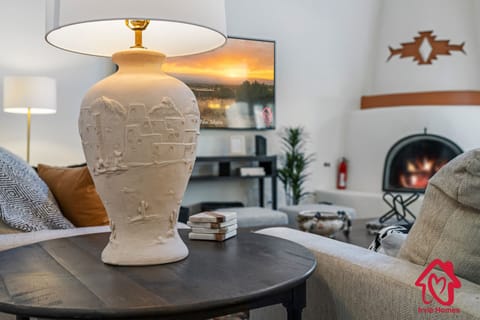 "Cozy Southwestern Living Room Ambiance with Artistic Table Lamp and Warm Fireplace"