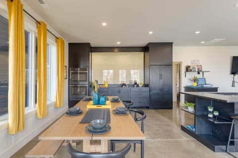 Large dining table is near the modern kitchen.