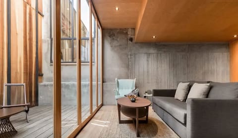 Large glass doors connect the living room to your outdoor terrace surrounded by greenery and bamboo.