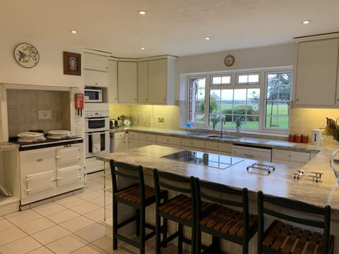 KITCHEN WITH AGA AND BREAKFAST BAR.