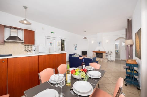 Open-plan living room with sofas, dining area, ornamental fireplace, WiFi internet, and satellite TV