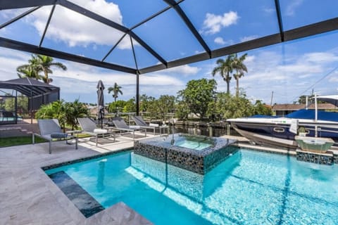Screened pool with spa and canal views, perfect for relaxing by the water.