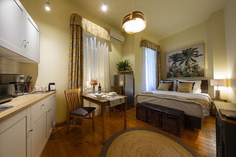 Spacious area featuring a fully equipped kitchen, dining table, and a comfortable bed, all set against a backdrop of lush, vibrant jungle-themed decor.
