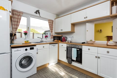 Well-equipped kitchen with an electric oven and hob and washing machine