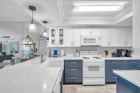 Spacious kitchen w/ crisp white cabinetry, blue accents, and plenty of prep space.