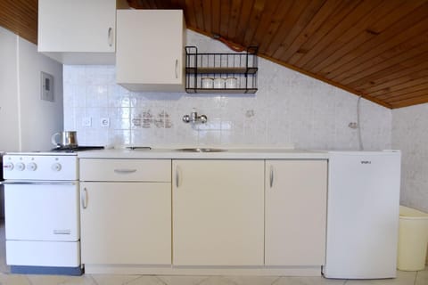 The kitchen with fridge and 3 burner stove