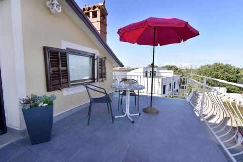 The terrace with table, chairs and umbrella at the entrance to the apartment