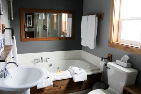 Refresh in a spotless bath with deep tub and bright vanity.