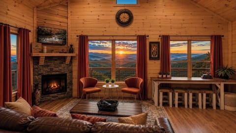 Living room with a stone fireplace and sweeping mountain views.