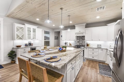 Kitchen with stainless steel appliances, gas range, mini bar.